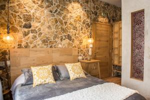 Magoúliana«Σκλάβας Χνάρι» Παραδοσιακός Ξενώνας的一间卧室设有一张床和石墙