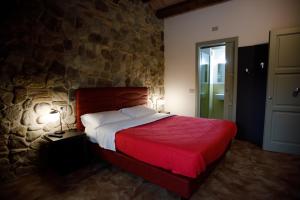 布里西盖拉Modus Aquae的一间卧室设有红色的床和石墙