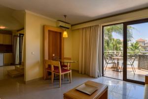 加藤-达拉特索Okeanis Golden Resort的一间带桌子的客厅和一个阳台