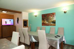 涅兹卡城堡Pokoje Gościnne的用餐室配有桌椅和墙上的绘画作品