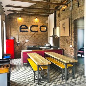 格拉纳达ECO Hostel的一间在房间内设有两张木长椅的餐厅