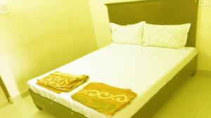 瓦朗加尔Vishnu Residency Warangal的一间卧室配有带金色床单和枕头的床。
