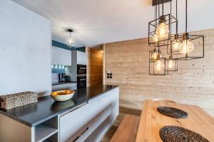 拉普德兹Apartment Wapa Alpe d'Huez - by EMERALD STAY的厨房配有黑色柜台和木桌