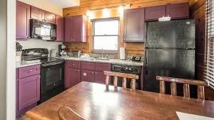 威斯康星戴尔蓝绿圣诞山村阿森德度假酒店的厨房配有紫色橱柜和黑色冰箱
