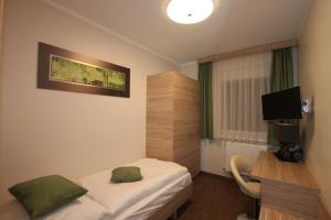 塞默灵塞默灵中心膳食旅店的酒店客房配有一张床、一张书桌和一台电视。