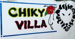 瓦塔穆Chiky Villa的墙上有鸡和花的标志