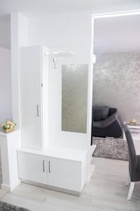 奥拉迪亚Gala Residence in Oradea的客厅里设有白色的镜子柜