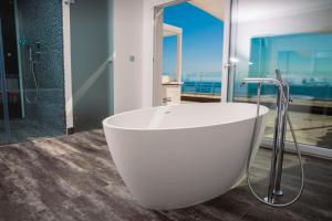罗萨斯维斯塔贝拉酒店的浴室设有白色浴缸,享有海景。