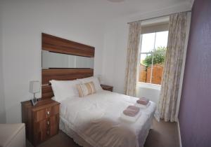 吉伦Links Corner的卧室配有白色的床和窗户。