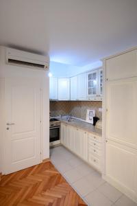 瓦列沃Apartman Centar Lux Valjevo的厨房配有白色橱柜和水槽