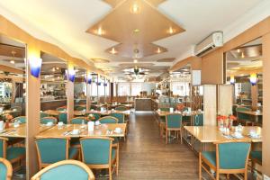 美因河畔法兰克福法兰克福萨克森豪森诺富姆酒店的餐厅设有木桌和蓝色椅子