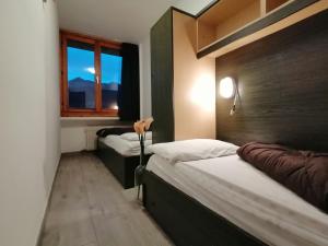 马里尔伊瓦Residence Abete的一间卧室设有两张床和窗户。