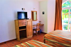 圣克鲁斯华特库Hotel Mexico Lindo的一间卧室配有一张床和一张书桌及电视