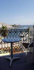 迈兹Hotel-Restaurant Du Port的阳台配有桌椅,享有水景