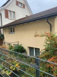 阿尔勒斯海姆Charming 2-Bed Apartment in Arlesheim 15 min Basel的花园前带围栏的房子