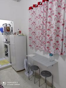 里约热内卢kitnet Maysa em Benfica RJ的厨房配有冰箱、桌子和2把椅子