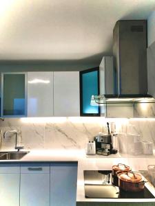 蒙特勒Fabulous Lakeside Family Apartment | 4 Rooms的厨房配有白色橱柜、水槽和炉灶。
