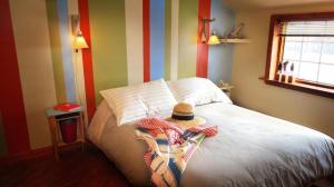 博纳旺蒂尔Auberge Café Acadien的一间设有一张带帽子的床的房间