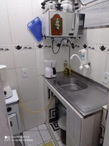 里约热内卢kitnet Maysa em Benfica RJ的一间带水槽和微波炉的小厨房
