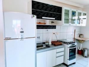 伊列乌斯Apartamento Modus Vivendi的白色的厨房配有冰箱和水槽