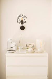 马拉加Blonski Guadalmar的白色梳妆台,配有咖啡壶和蜡烛