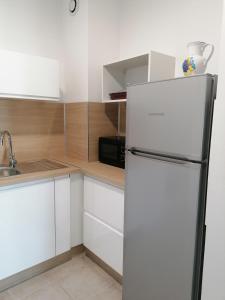 艾格-莫尔特Marina à Aigues Mortes - GARD的白色的厨房配有冰箱和水槽