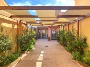 卡布拉斯Gioia Guesthouse的建筑的走廊,有遮阳篷和植物