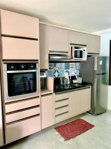 塔曼达雷Mauí beach resort的厨房配有白色橱柜和不锈钢用具