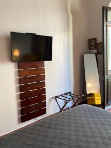 圣胡安352 Guest House Hotel Boutique的卧室配有壁挂式平面电视