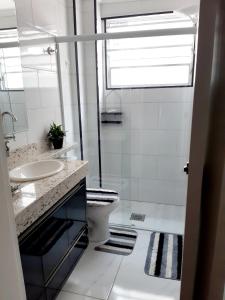 桑托斯Apartamento Edifício Turim Ponta da Praia Santos的白色的浴室设有水槽和卫生间。