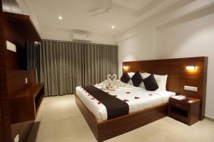 戈德亚姆Iswarya Residency的一间卧室配有一张红色玫瑰花大床