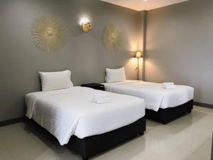 慕斯考艾格兰德斯里度假村的配有白色床单的酒店客房内的两张床