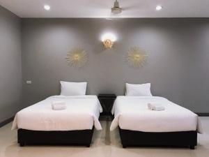 慕斯考艾格兰德斯里度假村的一间卧室配有两张带白色床单和两面镜子的床。