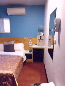 基隆永豐旅社的酒店客房设有两张床和蓝色的墙壁。