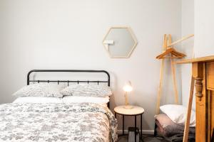 吉朗Quartz Cottage Geelong的一间卧室配有一张床和一张带台灯的桌子