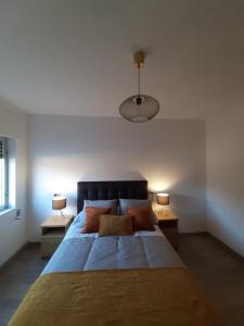 O PindoRío Ézaro的一间卧室配有一张大床、两张桌子和两盏灯。