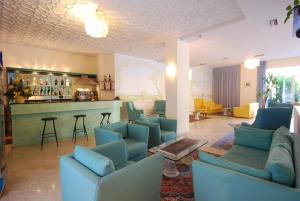 佩萨罗Hotel Caravelle的一间带蓝色沙发的客厅和一间酒吧
