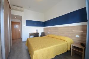 佩萨罗Hotel Caravelle的一间卧室设有黄色的床和蓝色的墙壁