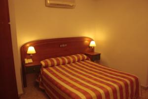 索托德尔雷亚尔阿萨德索托大旅馆 的酒店客房,配有一张带两盏灯的床