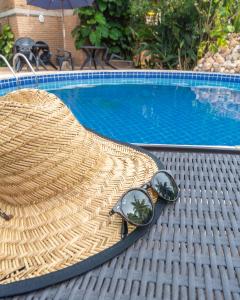 拉巴拉德纳圣米格尔月亮旅馆的坐在游泳池旁的草帽和太阳镜