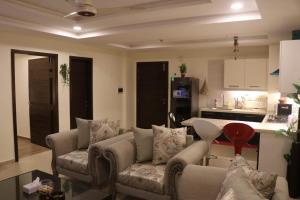 拉瓦尔品第Elegant & Charming One Bed Apartment In Bahria Town的带沙发的客厅和厨房