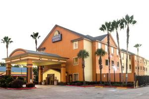 休斯顿休斯顿北戴斯套房酒店的停车场内棕榈树的酒店