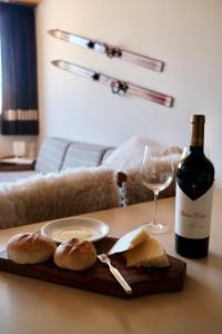拉斯莱尼亚斯Mountain Aparts Cirrus的一张桌子,上面放着一瓶葡萄酒、面包和一杯葡萄酒