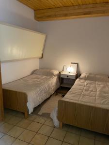 拉斯莱尼亚斯Mountain Aparts Cirrus的一间卧室配有两张床和一张带台灯的桌子