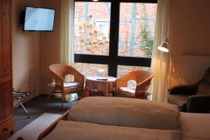 KüstenLandhotel Belitz Garni的客房设有床、椅子和窗户。