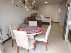拉古纳Residence Farol - Loft 219的一间带桌子和两把椅子的用餐室
