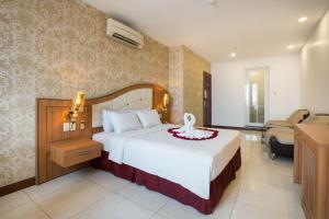 胡志明市Lam Kinh Hotel的一间卧室配有一张床,客厅配有沙发