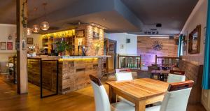 北安普敦核桃树酒店的一间带木桌的餐厅和一间酒吧