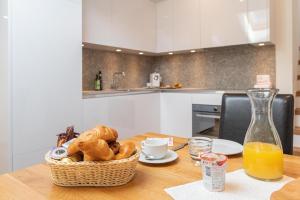 采尔马特乔利蒙特公寓酒店的一张桌子,上面放着一篮面包和一瓶橙汁