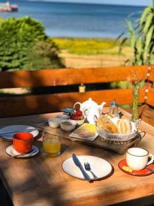 比亚里卡Hotel Costanera的一张木桌,早餐包括食物和饮料